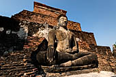 Thailand, Old Sukhothai - Wat Mahathat, square-based, multi-layered chedi with statues of seated Buddha at each side, stucco figures of lions and elephants decorate the base.